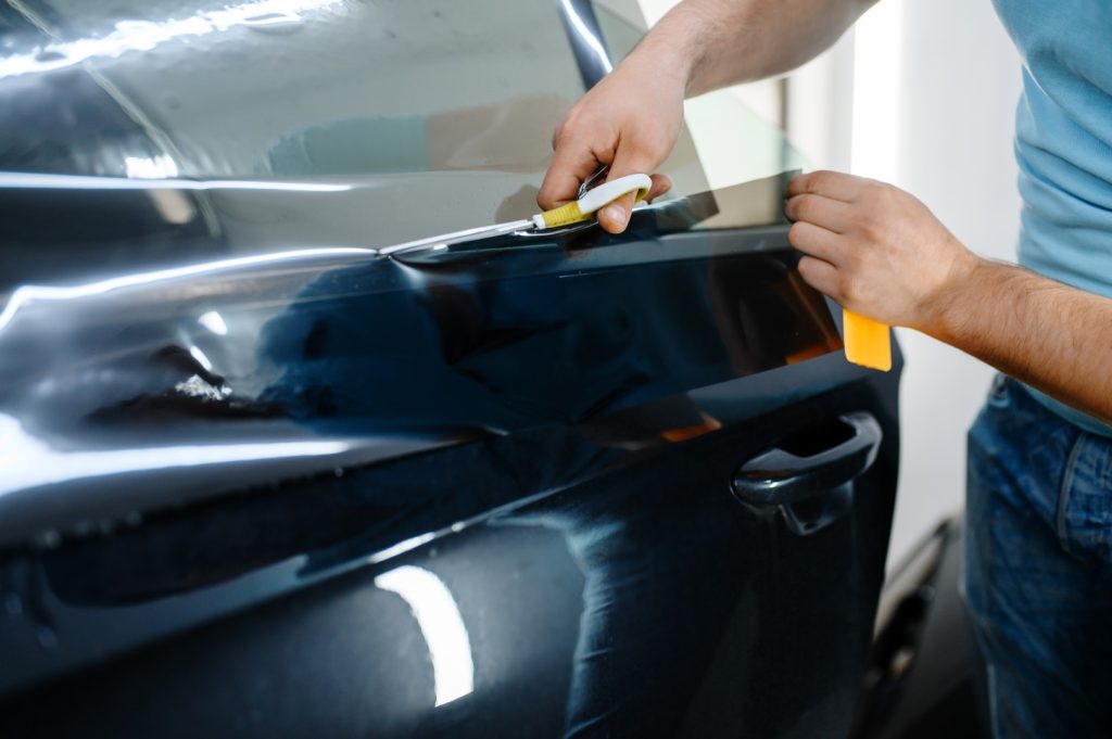 Car window tinting film being installed on a car door window.